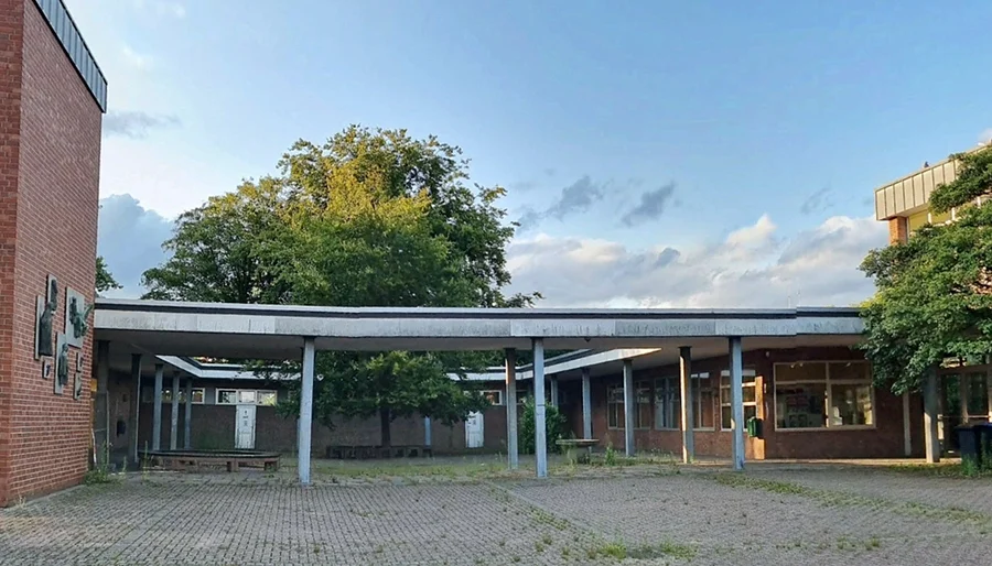 Ein Foto von der alten Schule mit dem kleinen Brunnen
