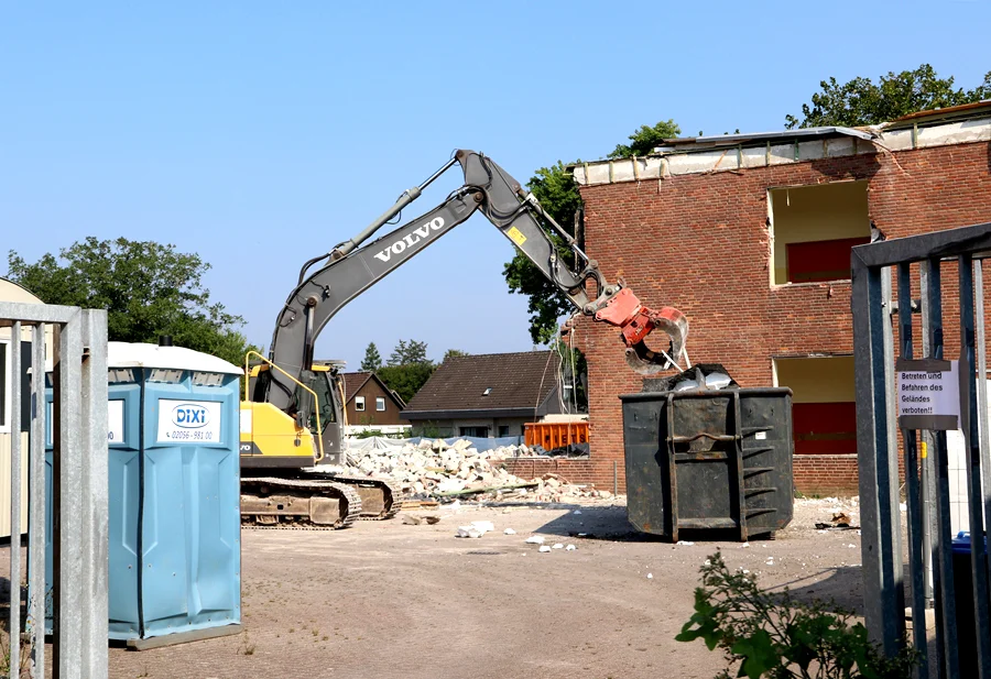 Greifbagger räumt den Schulhof auf