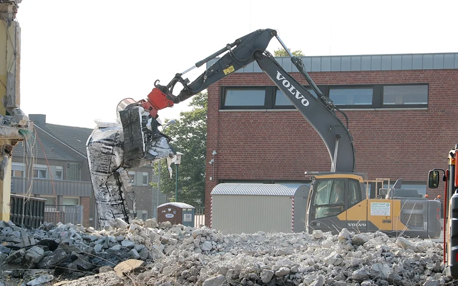 Bagger verlädt Abbruchmaterial auf dem Schulgelände in Weeze