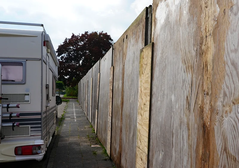 Eine lange Holzwand schützt die Baustelle der neuen Petrus-Canisius-Grundschule in Weeze vor neugierigen Blicken.
