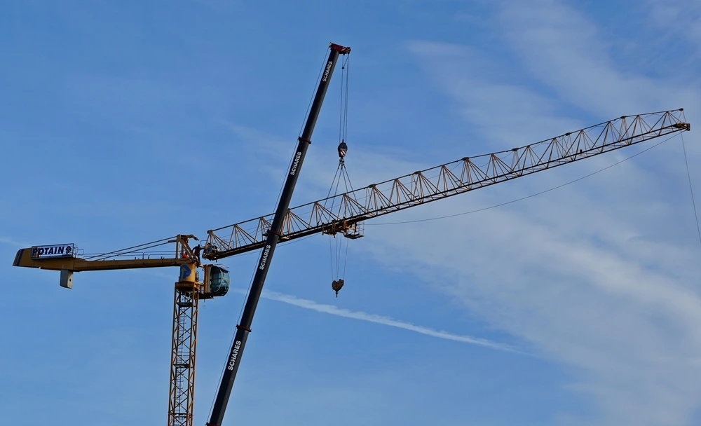 Mit einem großen Mobilkran wird auf der Baustelle in Weeze ein neuer Turmdrehkran aufgebaut.