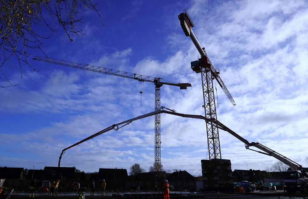 Zwei große Baukräne und eine Betonpumpe auf der Baustelle der neuen Petrus-Canisius-Grundschule in Weeze.