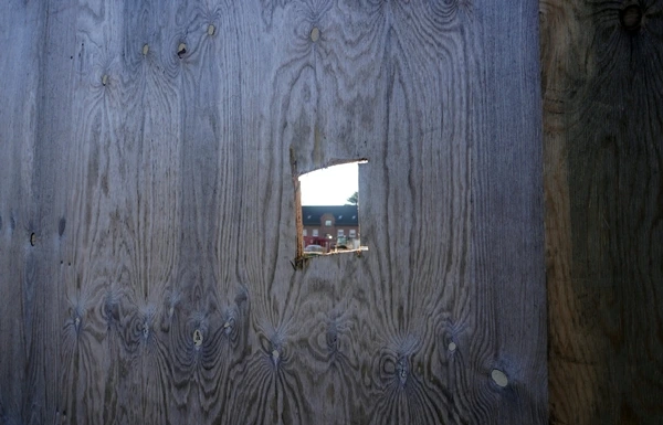 Ein kleines Guckloch in einer Holzwand der Baustelle gibt den Blick auf die neue Petrus-Canisius-Grundschule in Weeze frei.