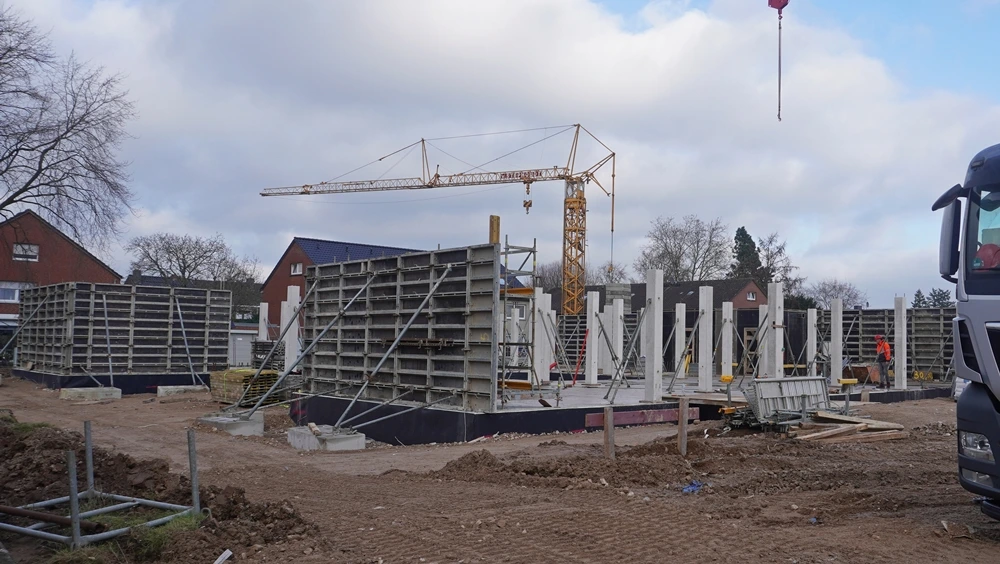 Die ersten Wände der neuen Petrus-Canisius-Grundschule in Weeze entstehen auf der Baustelle. Im Hintergrund steht ein Baukran.