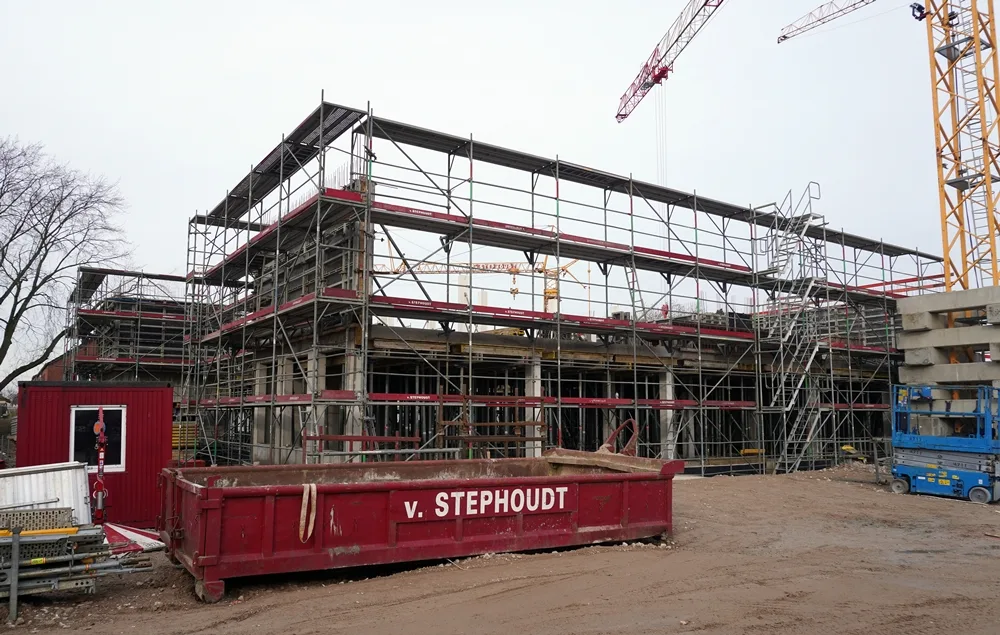 Die neue Petrus-Canisius-Grundschule in Weeze erreicht die zweite Bauphase. Rund um den Rohbau stehen große Baugerüste und Kräne.