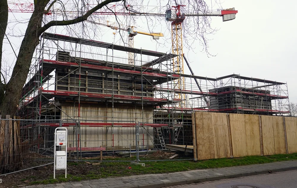 Die neue Petrus-Canisius-Grundschule in Weeze wächst weiter. Zwei Gebäudeteile stehen bereits im Gerüst zwischen mehreren Baukränen.