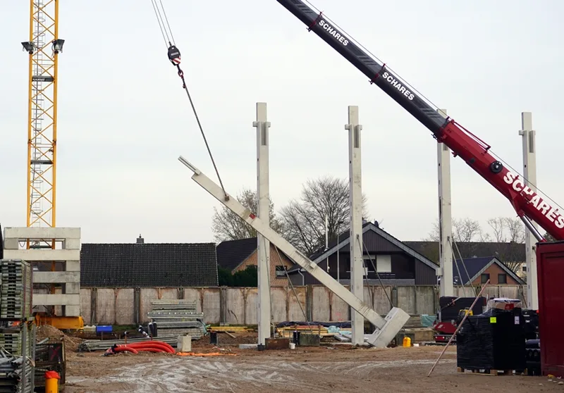 Mit einem großen Kran werden Betonteile für die neue Schulmensa der Petrus-Canisius-Grundschule in Weeze aufgestellt.
