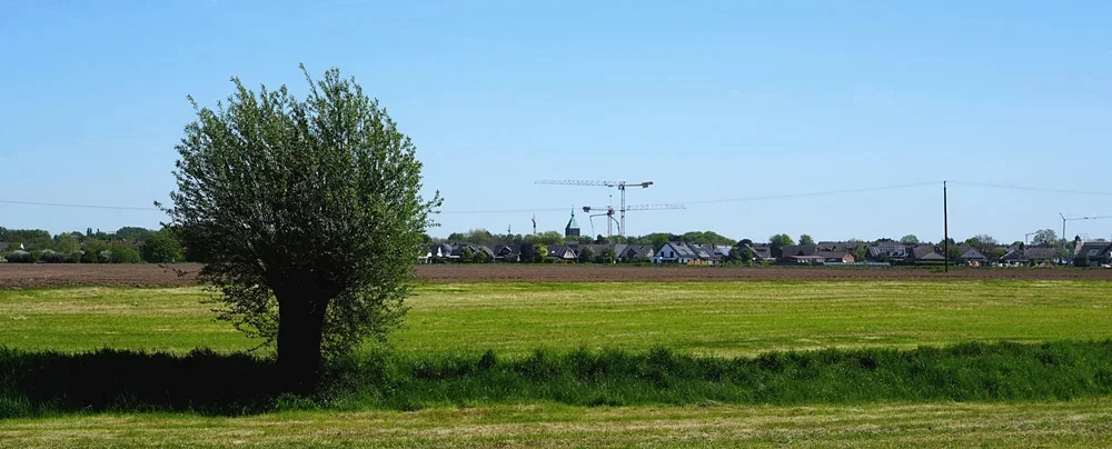 Panoramablick über Weeze – am Horizont ragen die Baukräne der neuen Petrus-Canisius Grundschule sichtbar in den Himmel
