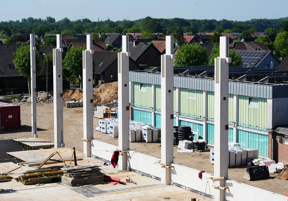 Die ersten hohen Betonstützen der neuen Sporthalle in Weeze ragen bereits sichtbar in den Himmel