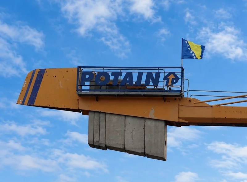 Eine Flagge weht hoch oben am Baukran über der neuen Petrus-Canisius-Grundschule in Weeze.