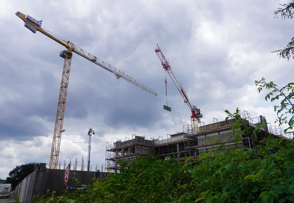 Ein Kran hebt eine Wandschalung über der Baustelle der Petrus-Canisius-Grundschule in Weeze.