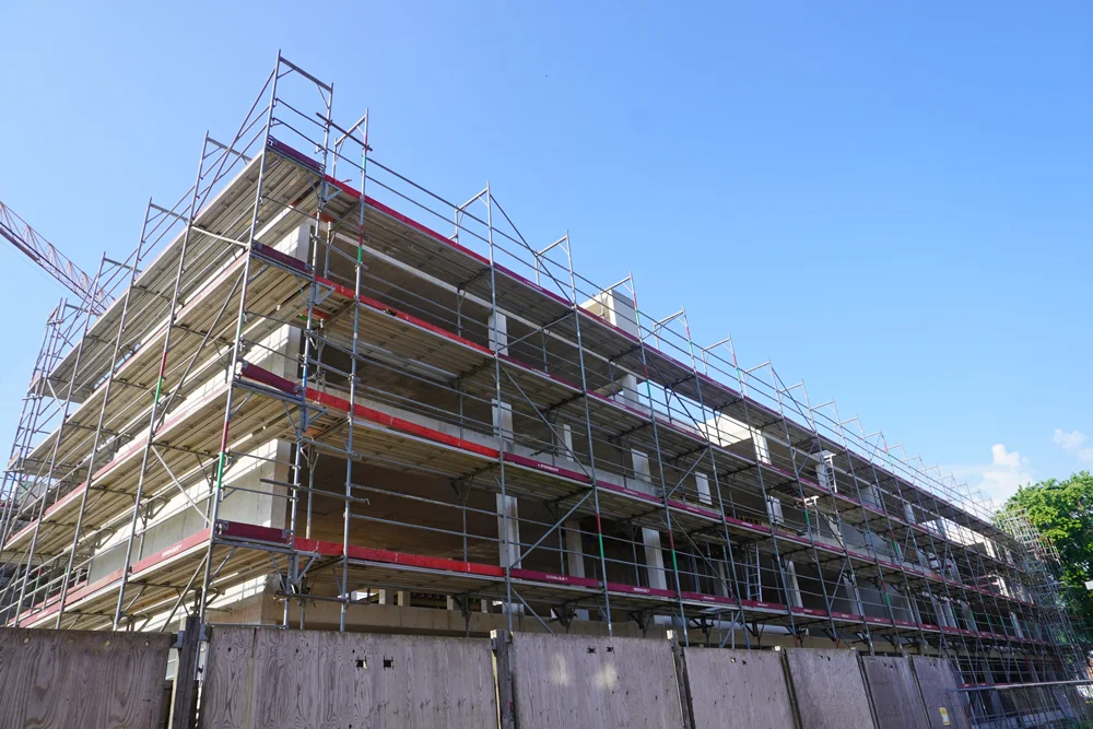 Rohbau der neuen Petrus-Canisius-Grundschule Weeze mit Gerüst, aufgenommen von der Wiesenstraße aus im Sommer 2026.