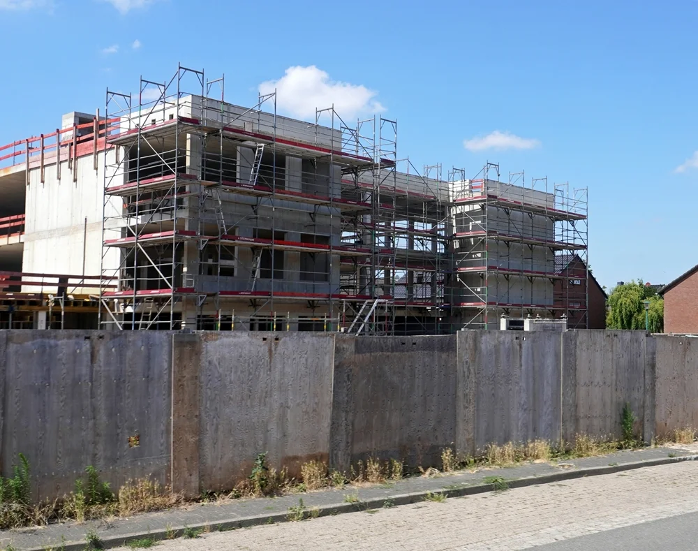 Seitenansicht des Rohbaus der neuen Grundschule in Weeze mit Baugerüsten im Juli 2026