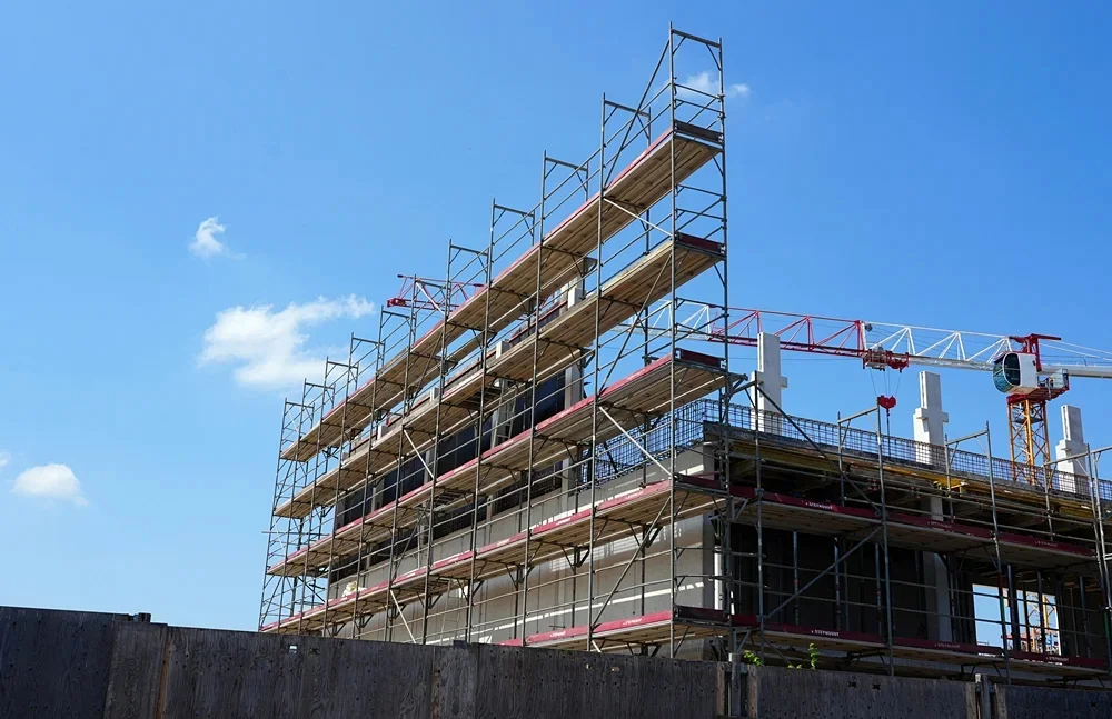 Baugerüst am Rohbau der Mensa und Sporthalle der neuen Grundschule in Weeze während der Bauarbeiten im Juli 2026.