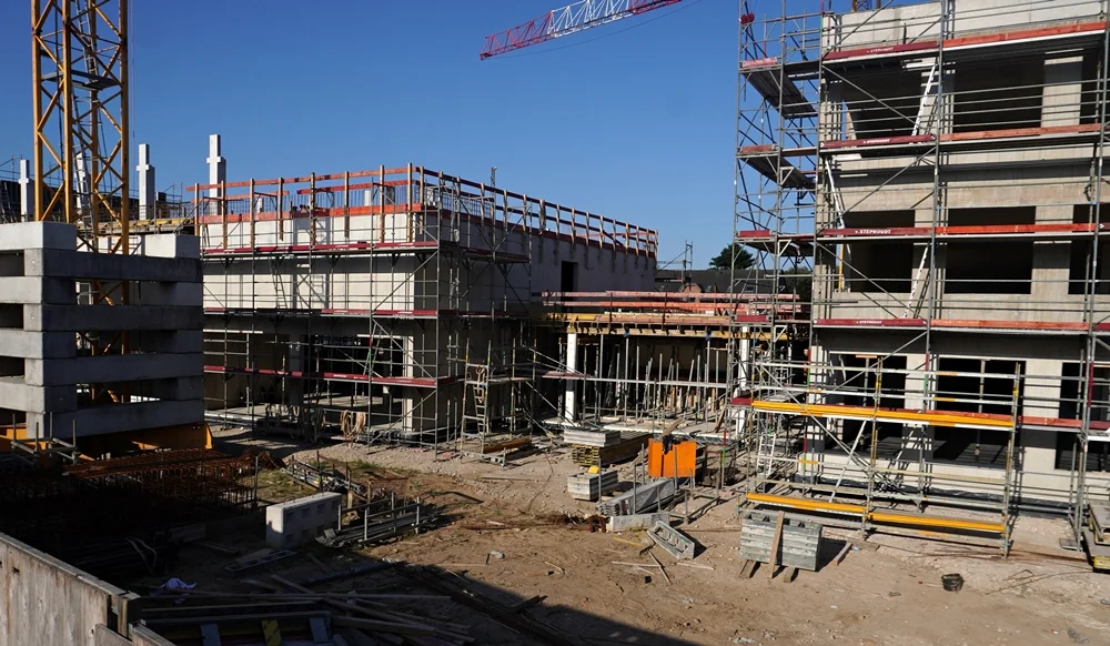 Seitenansicht des Rohbaus der neuen Grundschule in Weeze mit Baugerüsten im Juli 2026
