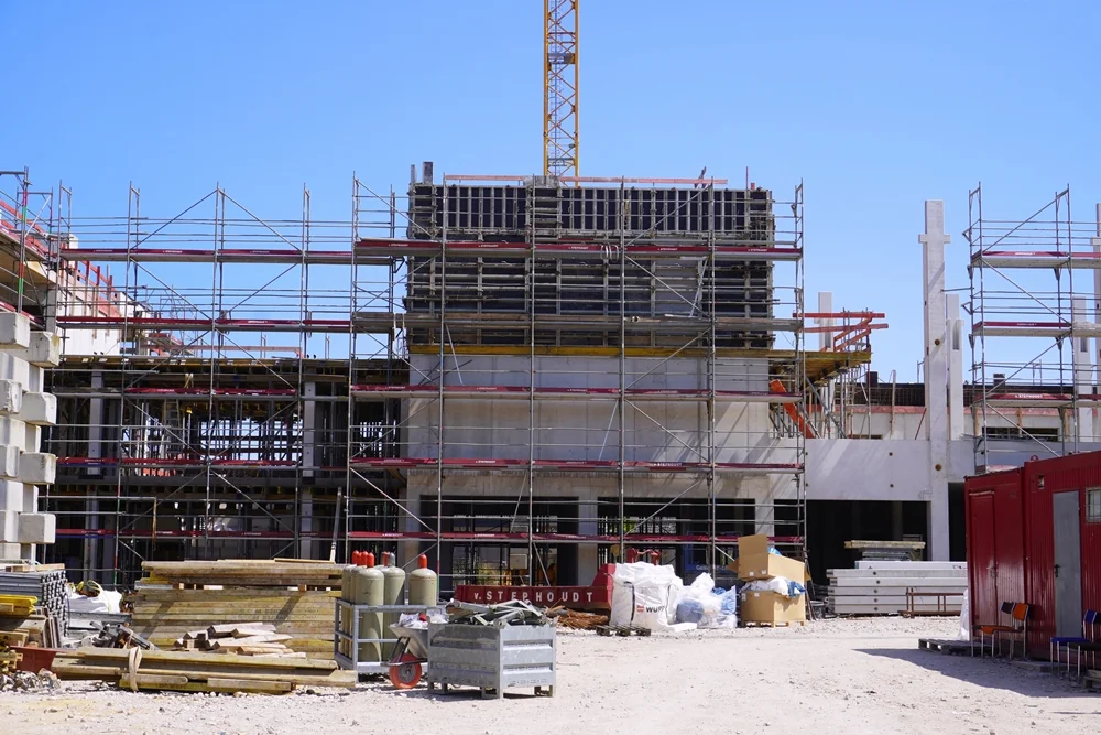 Der mittlere Gebäudeteil der neuen Petrus-Canisius-Grundschule in Weeze mit Baugerüsten, Schalung und Baumaterial während der Bauarbeiten.