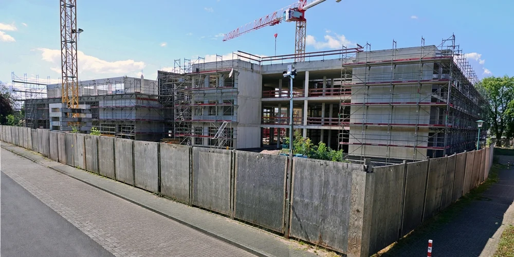 Blick von der Bodelschwinghstraße auf den eingerüsteten Schulneubau mit Baukränen in Weeze